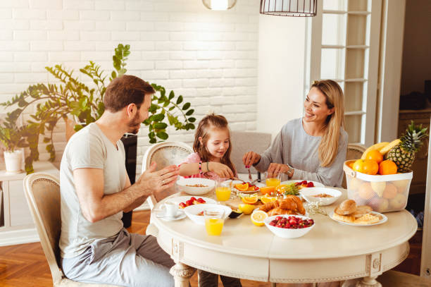 istock Happy young family having breakfast at home 1430553987