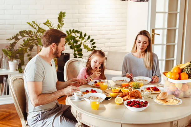istock Happy young family having breakfast at home 1430554006