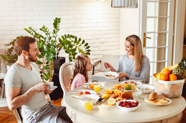 istock Happy young family having breakfast at home 1430554009