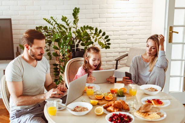 istock Young happy family having a breakfast and using modern technology 1430554011