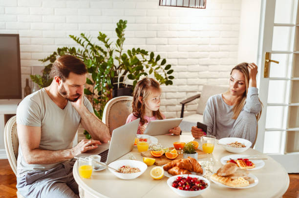 istock Young happy family having a breakfast and using modern technology 1430554024