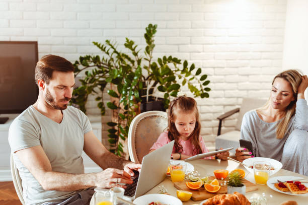 istock Young happy family having a breakfast and using modern technology 1430554034