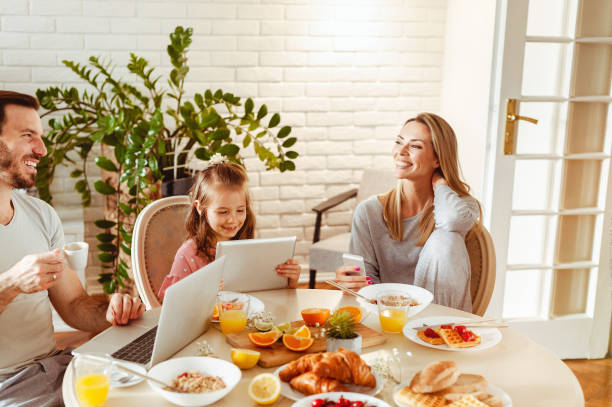 istock Young happy family having a breakfast and using modern technology 1430554035