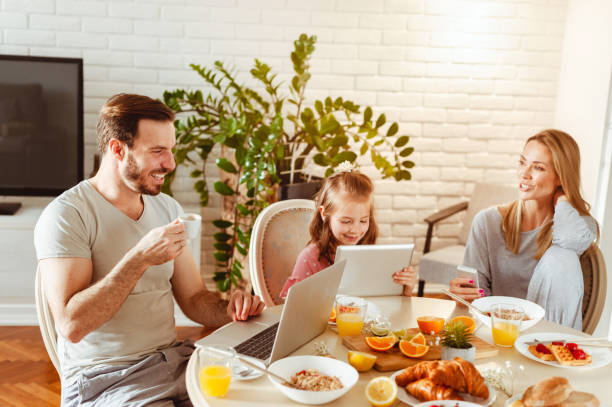 istock Young happy family having a breakfast and using modern technology 1430554041