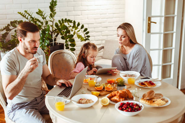 istock Young happy family having a breakfast and using modern technology 1430554053