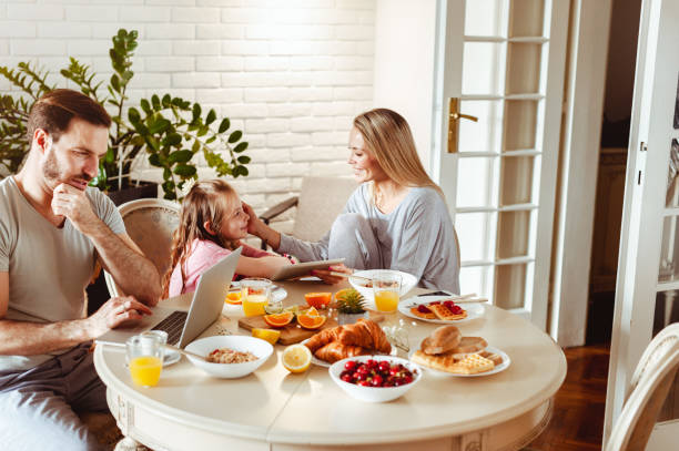 istock Young happy family having a breakfast and using modern technology 1430554059