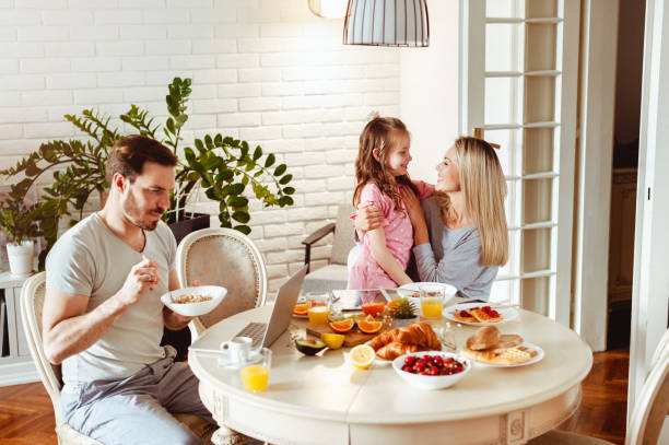 istock Happy young family having breakfast at home 1430554066