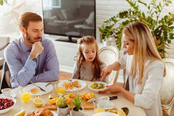 istock Busy young family having healthy breakfast, dressed up for work and school 1430554100