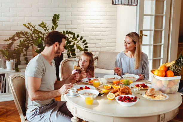 istock Happy young family having breakfast at home 1430554108