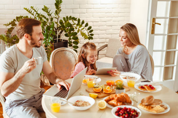 istock Happy young family having breakfast at home 1430554116