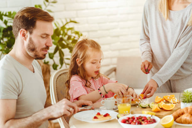 istock Happy young family having breakfast at home 1430554141