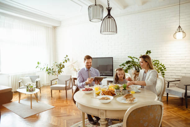 istock Happy young family having breakfast at home 1430554171