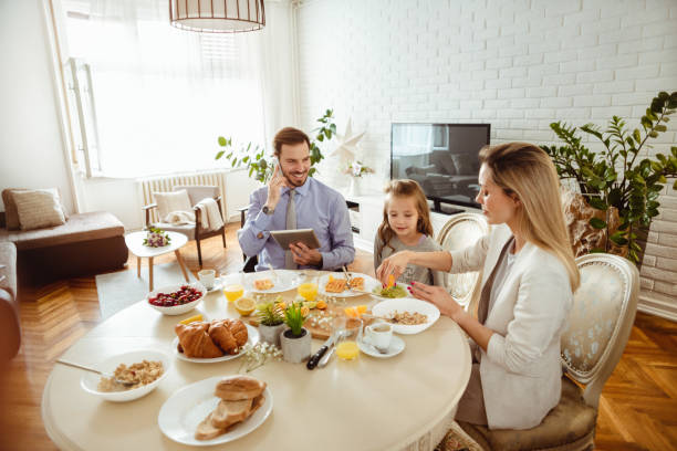 istock Happy young family having breakfast at home 1430554173