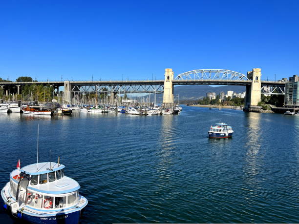 Bridge to greenville and water bus passing under the bridge Nature Canada Vancouver Pacific Ocean Pier and pillars on the pier Granville Island aquabus Skyscrapers in the background Bridge to greenville and water bus passing under the bridge Nature Canada Vancouver Pacific Ocean Pier and pillars on the pier Granville Island aquabus Skyscrapers in the background 09.2022 Canada sea population stock pictures, royalty-free photos & images