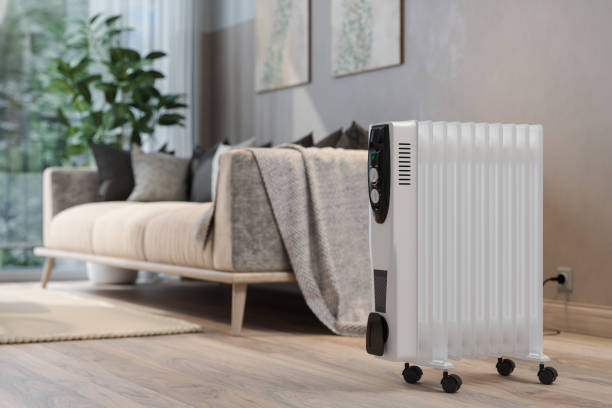 ぼやけた背景のリビングルームの電気ラジエーターヒーターのクローズアップビュー - electric heater ストックフォトと画像