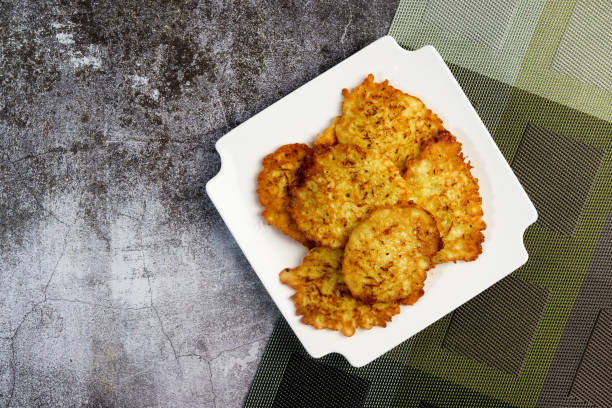 istock Rustic homemade Zucchini pancakes on a white square  plate on a dark background. Top view, flat lay 1430561845