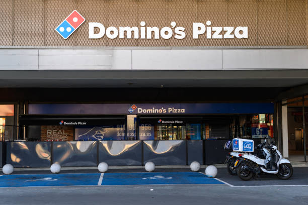 fasada pizzerii domino's na zewnątrz z dwoma motocyklami dostawczymi przy drzwiach - dominos pizza zdjęcia i obrazy z banku zdjęć