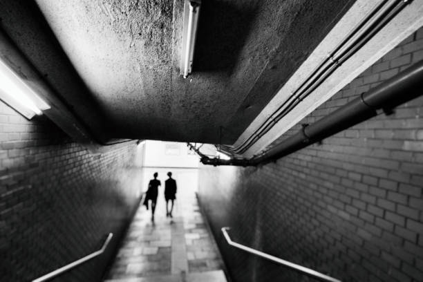 istock Rear view of two men in a dark underground passage 1430565142