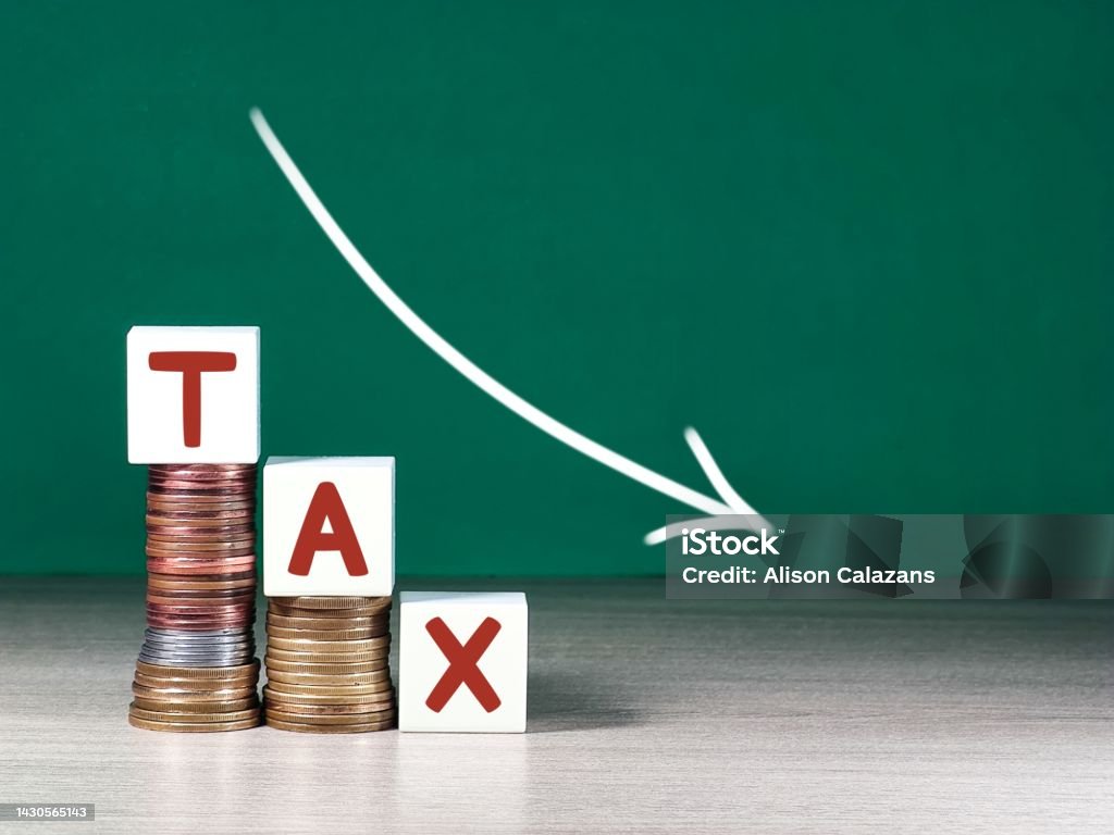 cubes with the word Tax on money pile of coins cubes with the word Tax on money pile of coins. Tax Stock Photo