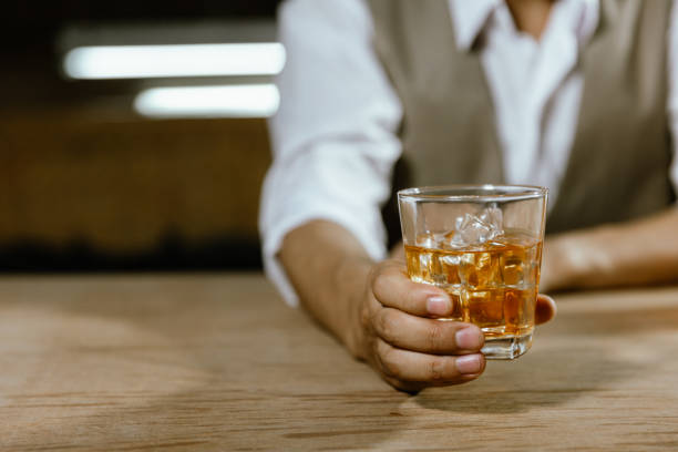 istock Close-up bartender holding a glass of whiskey 1430567614