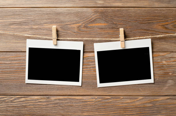 istock Empty photos are hanging on a rope. A design element. Brown wooden background. Copy space. 1430573626