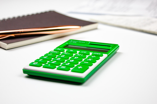 The green calculator next to accounting documents.Financial concept with calculator.