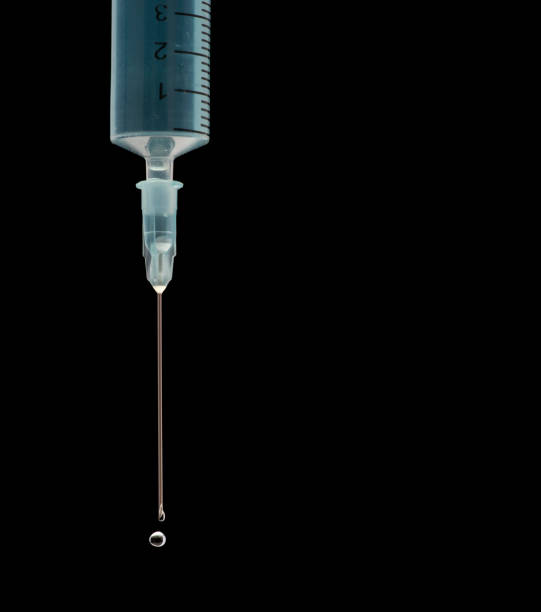 seringue médicale montrant un liquide bleu expulsé sous pression - demisemiquaver photos et images de collection