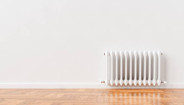 3D heating radiator on white wall at home 3D rendering of cast iron heating battery attached to white wall in spacious apartment with parquet floor space heater stock pictures, royalty-free photos & images