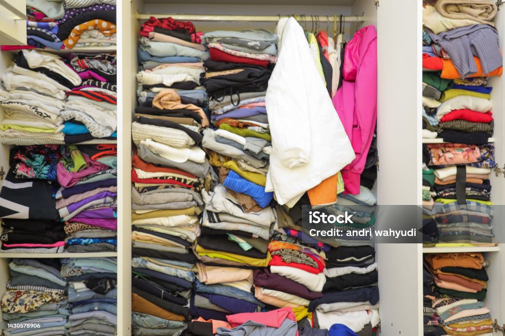 Messy wardrobe with different clothes.  Fast fashion and shopper concept Closet Stock Photo
