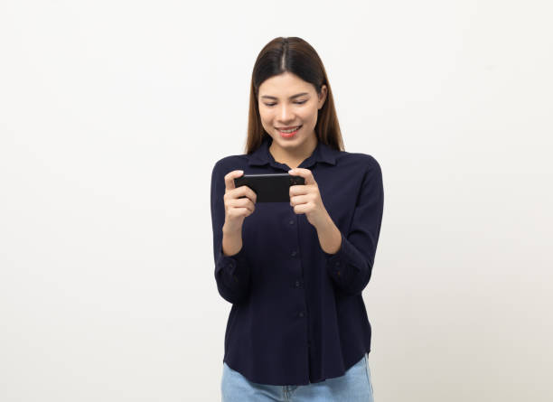 istock Pretty young mixed race woman using smartphone standing on isolated white background. She texting on cell phone. Feeling happy and excited 1430579568