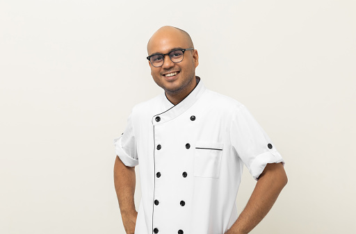 Smiling Young handsome asian man chef in uniform with glasses  casual posing on isolated background. Cooking man Occupation chef or baker People in kitchen restaurant and hotel.
