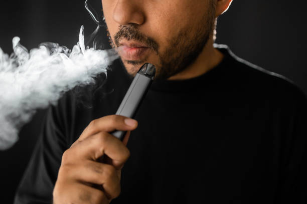Close-up mouth of man smoke inhaling, breathing and smoke electronic cigarette. Close-up mouth of man smoke inhaling, breathing and smoke electronic cigarette. liquid battery stock pictures, royalty-free photos & images