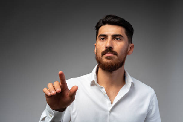 istock Young Arab businessman working with virtual screen over grey background. 1430582742