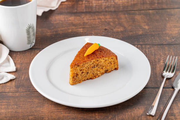 Delicious carrot cake with coffee next to it on wooden table stock photo