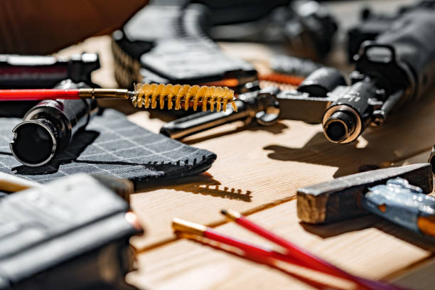 istock Black disassembled shotgun and cleaning tools on wooden table . 1430587046