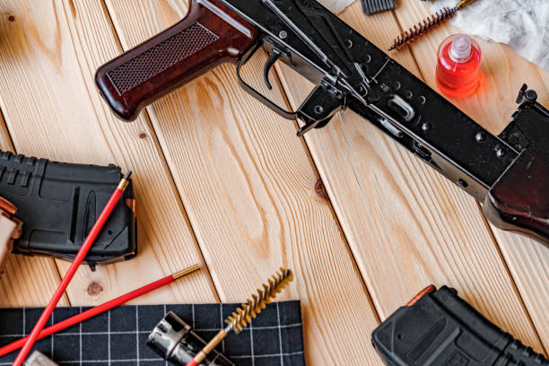 istock Black disassembled shotgun and cleaning tools on wooden table . 1430590944