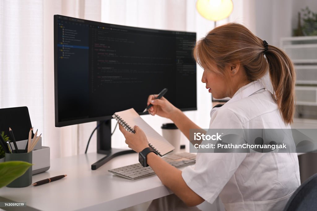 Young Female Programmer Working With Coded Data On Desktop Computer In ...