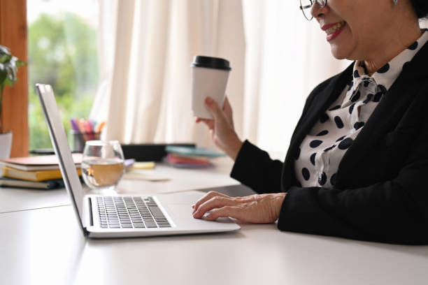 istock Smiling senior businesswoman wearing elegant formal suit using laptop computer in modern personal office. 1430592501