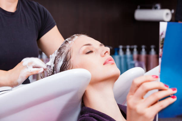 Hairdresser washing woman's hair after dyeing Hairdresser washing woman's hair after dyeing. retouching stock pictures, royalty-free photos & images