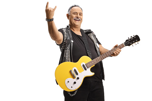 Mature rock guitarist with an electric guitar gesturing a rock and roll sign isolated on white background