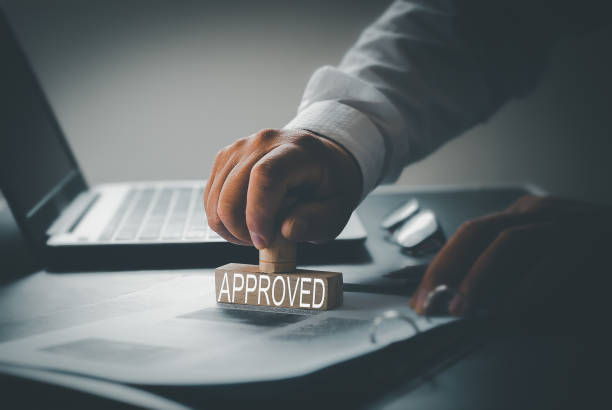 istock Business approval and certificate concept. Close-up of person's hand stamp with certification stamp on document. At desk, lawyer or businessman document signing. 1430595683