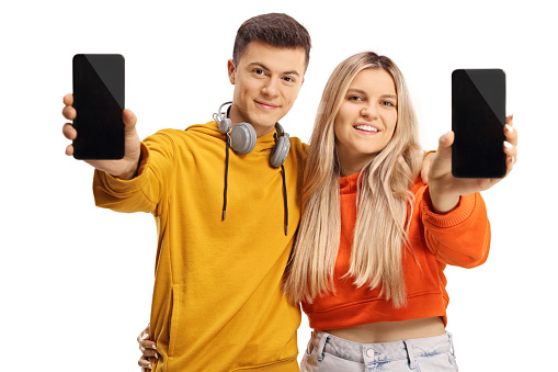 Teen male and female showing smartphones and smiling isolated on white background