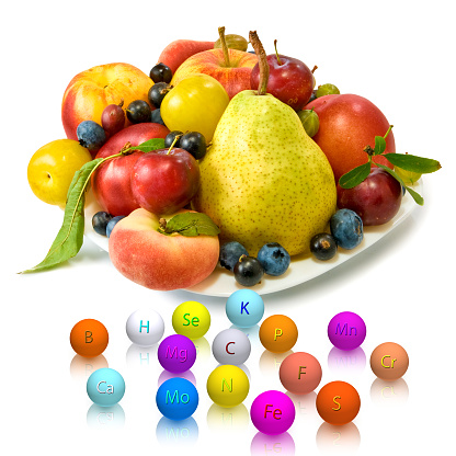The image of fruits and trace elements in the form of balls with the designation of a trace element on a white background. 3D-rendering