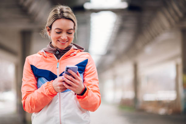 istock Young woman taking a break from jogging outside and using smartphone 1430599815