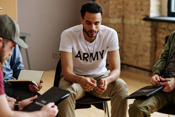 istock Young upset multi-ethnic man sitting among other people during session 1430600354