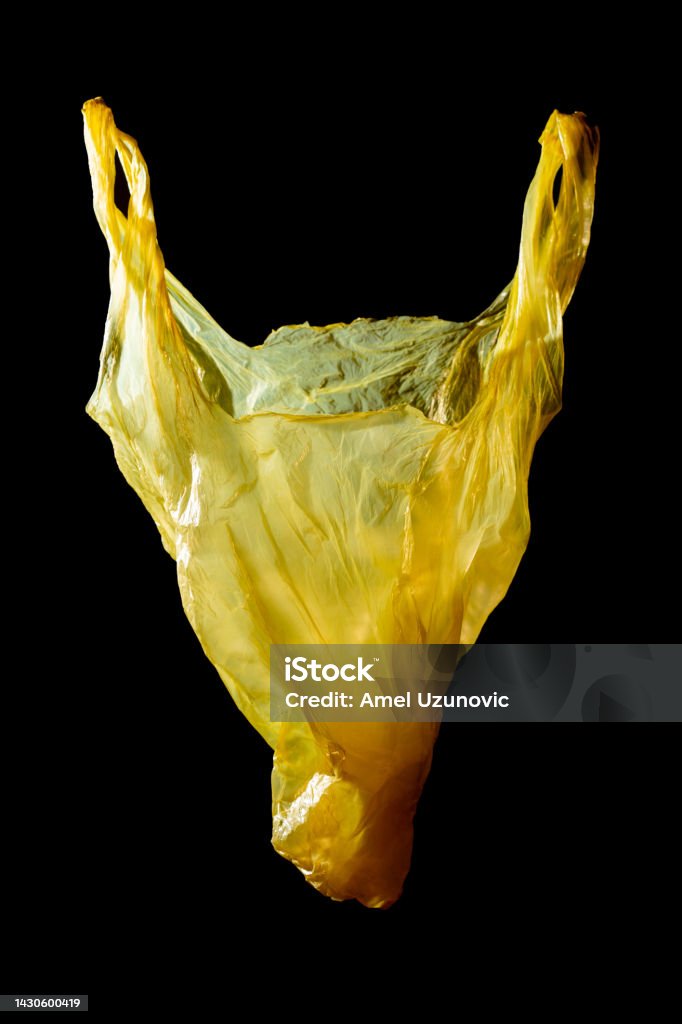The head of an animal, a horse or a cow made of a yellow plastic bag on a dark background. problem of plastic waste, pollution, microplastics creative minimal concept. Contemporary surreal art Art Stock Photo