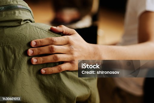 istock Hand of young supportive man consoling his friend with post traumatic syndrome 1430601013