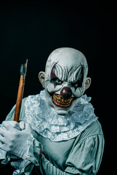 istock creepy evil clown lifts a blood-stained axe 1430610579