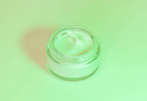 istock Opened Cosmetic jar close up, mockup. Green light. Everyday skincare routine 1430611884
