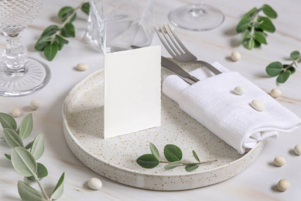 istock Table setting with folded card decorated with eucalyptus branches close up, Wedding mockup 1430611927